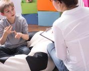 Boy talking to woman with clipboard